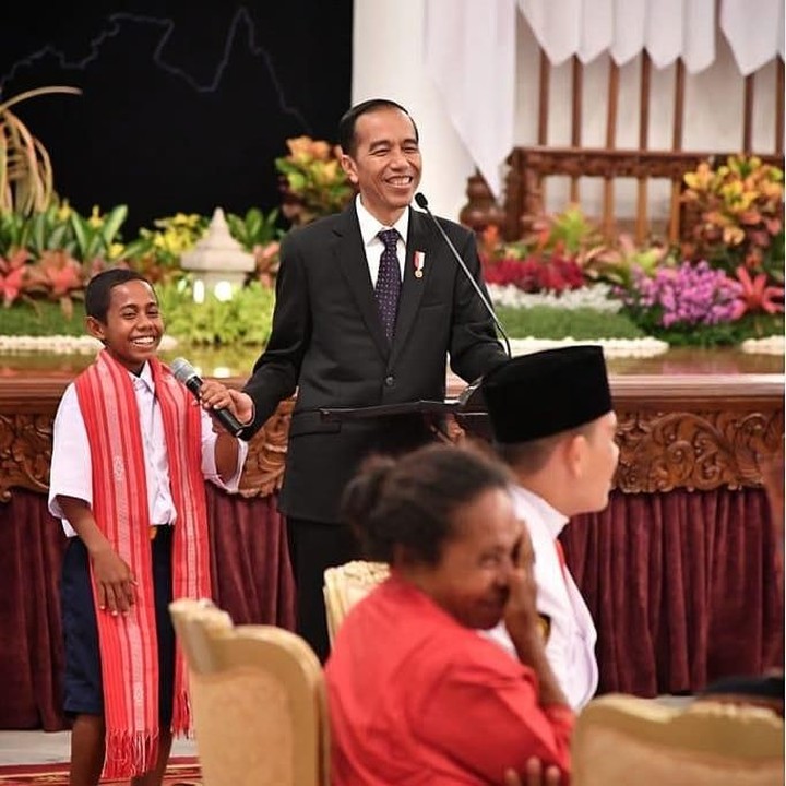 <p>Familiar dengan wajah anak kecil di samping Jokowi ini, Bun? Ya, dia Joni, yang terkenal lewat aksi heroiknya memanjat tiang bendera untuk meraih ujung tali yang tersangkut, saat perayaan 17 Agustus 2018 di Belu, NTT, membuatnya diberi kesempatan bertemu Jokowi. (Foto: Instagram @jokowi)</p>