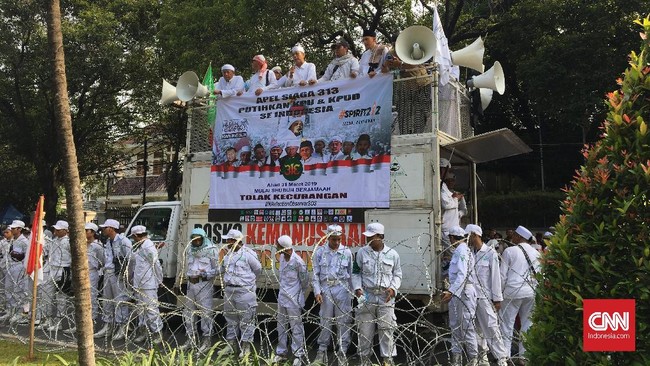 Massa aksi 313 yang mayoritas berseragam putih membawa poster bertuliskan "Tolak Kecurangan Pemilu". Mereka bagian dari FPI dan FUI.