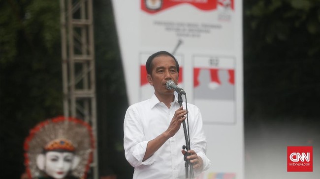 Massa mengenakan kaos putih bergambar Ma'ruf Amin dengan caping merah-putih di telinganya memeriahkan kampanye Jokowi di Stadion Singaperbangsa, Karawang.