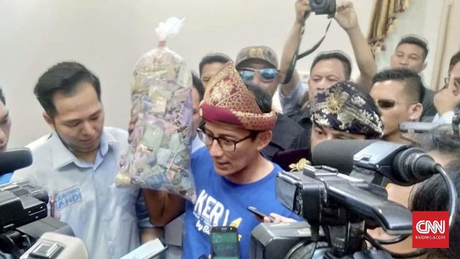 Sandiaga Uno menerima satu kantong plastik besar berisi uang di Palembang yang akan disumbangkan untuk relawan yang berjaga di TPS dan emak-emak di dapur umum.