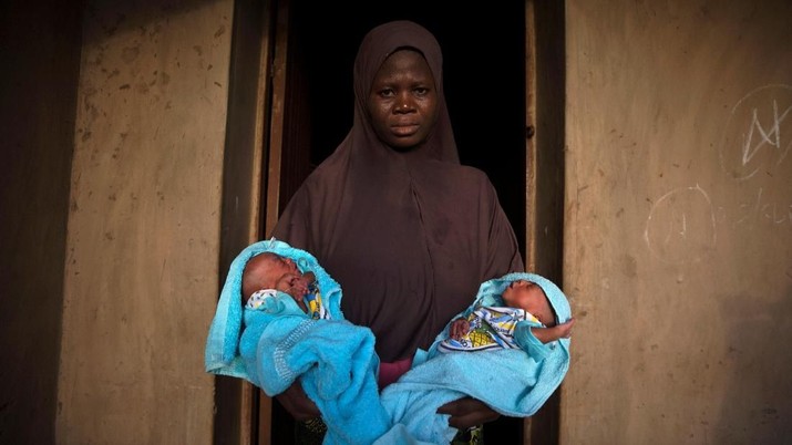 A Muslim woman carries her four-day-old male twins wrapped in blue towels outside the door of her home in Igbo Ora, Oyo State, Nigeria April 3, 2019. PIcture taken April 3, 2019. REUTERS/Afolabi Sotunde