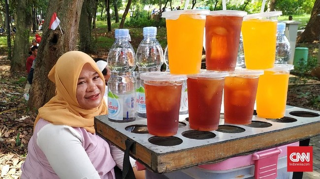 Iis, asal Cikampek, bersama suami dan anaknya tiba pukul 02.00 WIB dini hari, di kawasan SUGBK untuk berjualan es teh manis, es jeruk, serta air mineral.