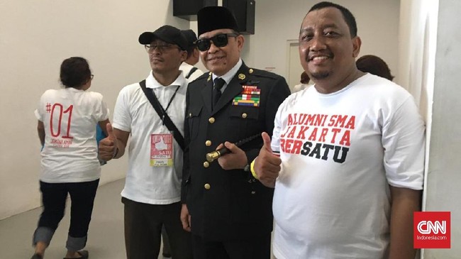 Sosok Presiden Sukarno ini mengenakan pakaian dinas lengkap dengan badge, tongkat, kacamata dan peci hitam. Dia diajak foto bersama pendukung Jokowi di GBK.