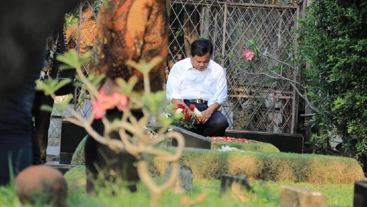Dalam sebuah foto, capres nomor urut 02, Prabowo Subianto, terlihat duduk di samping makam sang ayahanda.