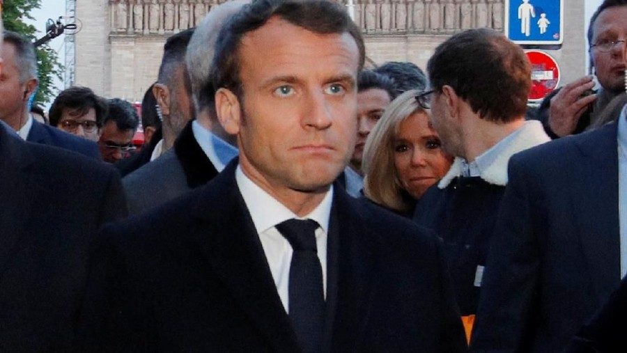 French President Emmanuel Macron walks near the Notre Dame Cathedral as its burns in Paris, France, April 15, 2019.   REUTERS/Philippe Wojazer