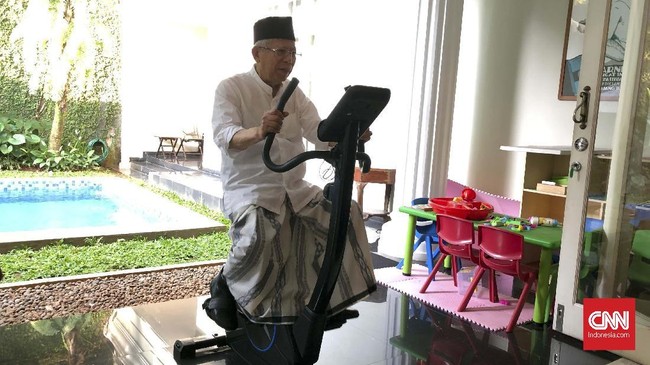 Sambil mengenakan kemeja putih, peci dan sarung, Ma'ruf Amin mengayuh sepeda statis di rumahnya sebelum mencoblos pagi hari ini. Dia mengaku senang berolahraga.