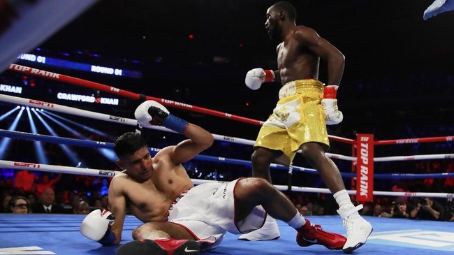Terence Crawford berhasil mempertahankan gelar juara dunia tinju kelas welter WBO setelah Amir Khan tak mampu melanjutkan pertarungan di Madison Square Garden.