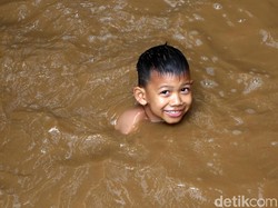 Keceriaan Anak-anak Bukit Duri Bermain di Tengah Banjir