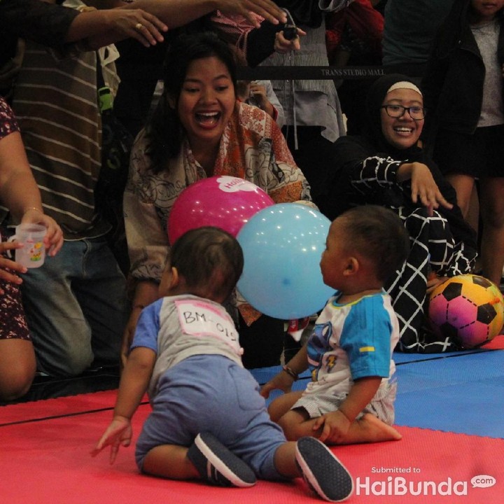 Saat lomba merangkak, orang tua memberikan umpan dari HP, boneka, dompet, sampai foto si anak, agar anak bisa tiba di finis. (Foto: Yuni Ayu Amida)<div dir="auto" style="font-family: sans-serif; font-size: 12.8px;"> </div>