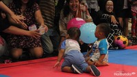 Saat lomba merangkak, orang tua memberikan umpan dari HP, boneka, dompet, sampai foto si anak, agar anak bisa tiba di finis. (Foto: Yuni Ayu Amida)<div dir="auto" style="font-family: sans-serif; font-size: 12.8px;"> </div>