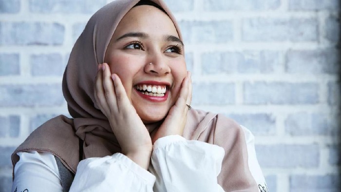 A women touch her face and smile with excitement