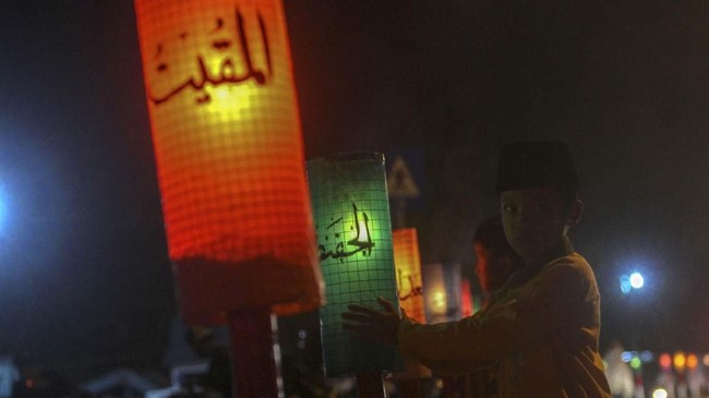 Sejumlah anak berada di dekat lampu hias bertuliskan 99 Asmaul Husna yang dipajang di kawasan Masjid Istiqamah saat salat tarawih pertama bulan Ramadan 1440 H di Pekanbaru, Riau, Minggu (5/5/2019). Lampu hias atau yang biasa dikenal dengan istilah lampu colok ini dibuat pengurus masjid untuk memeriahkan suasana bulan suci Ramadhan. ANTARA FOTO/Rony Muharrman/aww.