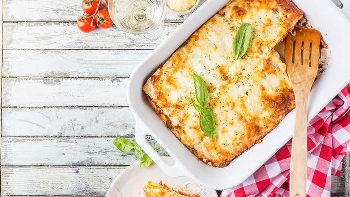Traditional italian lasagna with vegetables, minced meat and cheese. On a wooden background. Top view, copy space