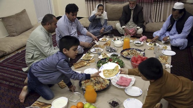 An Afghan family breaks their fast with the Iftar meal at sundown, on the first day of the holy month of Ramadan, in Kabul, Afghanistan, Monday, May 6, 2019. Muslims throughout the world are celebrating Ramadan, the holiest month in the Islamic calendar, refraining from eating, drinking, smoking and sex from sunrise to sunset. (AP Photo/Rahmat Gul)