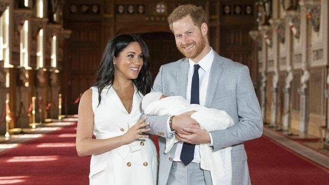 Meghan Markle mengenakan gaun putih rancangan Givenchy dalam debut penampilannya bersama si buah hati.