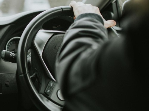 Hayward Heaths, England - October 27th, 2018: Detail of Toyota Auris car dashboard being driven by young man with the hand on the steering wheel, with daylight, with right-hand position.