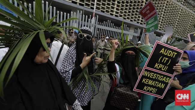 Sebagian emak-emak yang ikut aksi di depan gedung Bawaslu berusaha menyingkirkan kawat berduri agar bisa masuk ke gedung pengawas pemilu itu.
