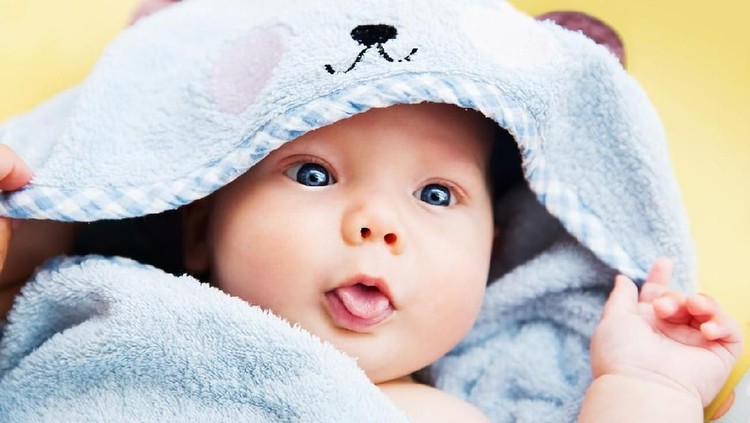 Cutest baby child after bath with towel on head. Adorable smiling baby boy!