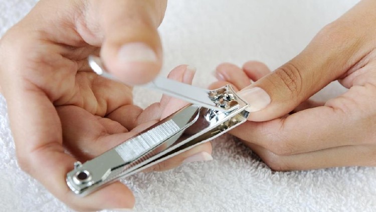 Nail technician clipping customers nails at the nail salon