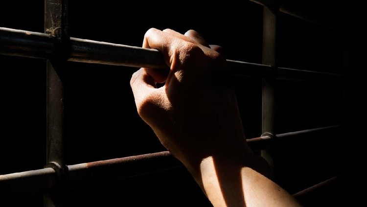 anak dipenjara Close up Man hands are holding the cage door in dark room