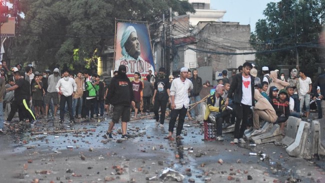 Massa pengunjuk rasa dan aparat masih saling lempar di Jalan Brigjen Katamso, Slipi, Jakarta Barat hingga Rabu (22/5) malam.