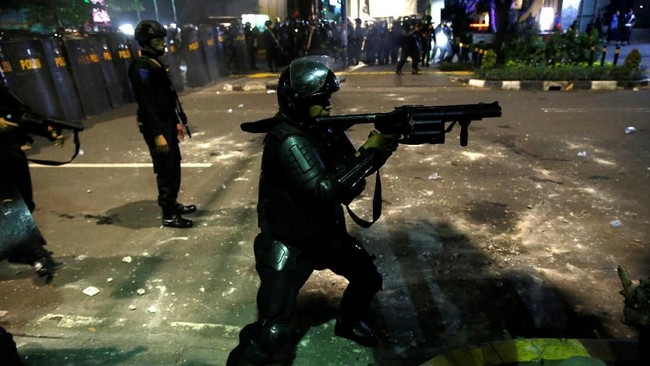 Dua kendaraan water cannon atau meriam air mengapit polisi yang maju untuk membubarkan massa di Wahid Hasyim, Jakarta Pusat. Massa berhasil dipukul mundur.