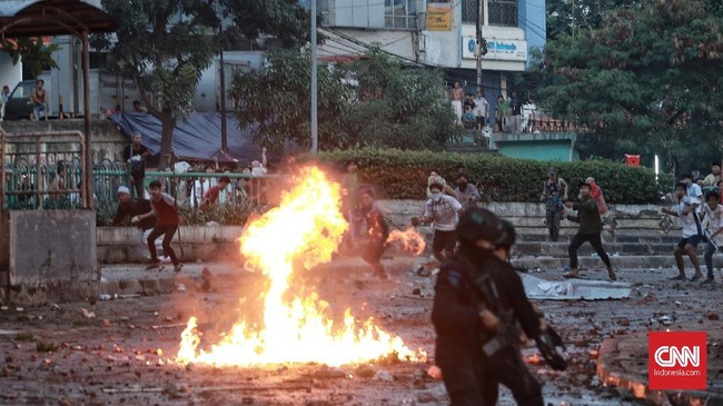 Massa melakukan pembakaran di area asrama Brimob di Petamburan, Jakarta, Rabu dini hari. Petugas lalu membubarkan massa hingga kabur ke permukiman warga.