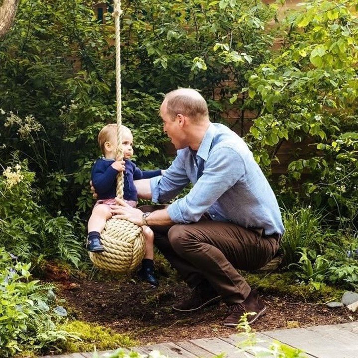<p>Sambil jongkok, Pangeran William, menjaga Pangeran Louis saat bermain ayunan. (Foto: Instagram @kensingtonroyal)</p>