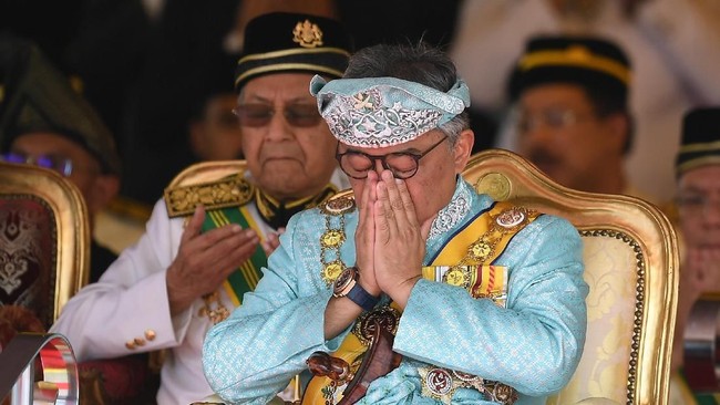 The incoming 16th King of Malaysia, the sixth Sultan of Pahang, Al-Sultan Abdullah Ri'ayatuddin Al-Mustafa Billah Shah Ibni Sultan Ahmad Shah Al-Musta'in Billah (R) and Malaysia's Prime Minister Mahathir Mohamad (L) pray during the welcoming ceremony at the Parliament House in Kuala Lumpur on January 31, 2019. (Photo by MOHD RASFAN / AFP)