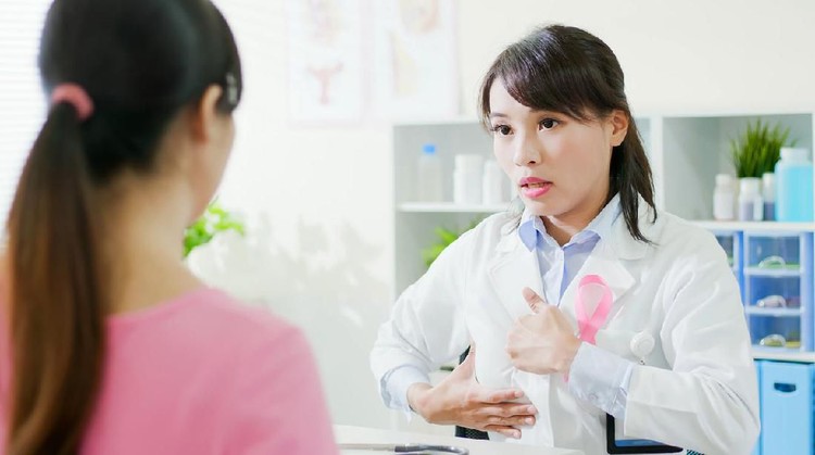 Breast cancer prevention concept - female doctor teach the patient how to self check breast