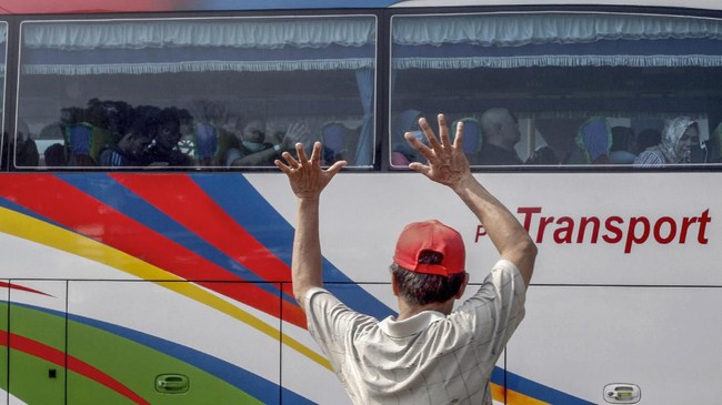Warga melambaikan tangan kepada sanak keluarganya yang mudik di Terminal Jatijajar, Depok, Jawa Barat, Kamis (30/5/2019). Menurut Badan Pengelola Transportasi Jabodetabek (BPTJ) puncak arus mudik di Terminal Jatijajar diprediksi akhir pekan ini, mulai dari Jumat hingga Sabtu. ANTARA FOTO/Yulius Satria Wijaya/wsj.