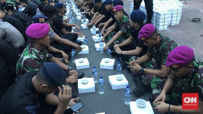 Dipelopori Pagar Nusa NU, TNI dan Polri berbuka puasa bersama, Kamis (30/5). Mereka duduk berdampingan di atas aspal jalanan, depan Gedung Mahkamah Konstitusi.