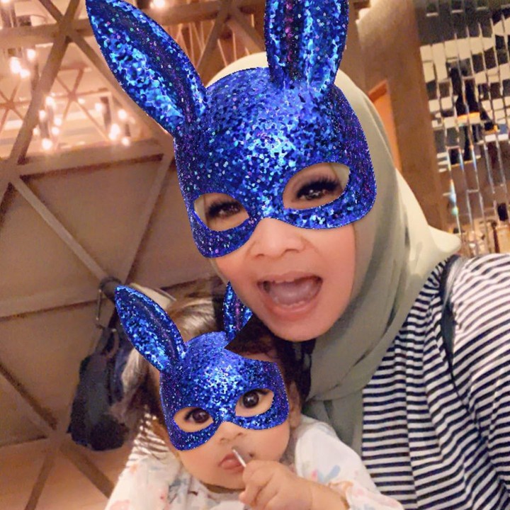 <p>Sekarang pakai <em>filter</em> topeng berwarna biru berkilauan. Wah ekspresi Ansara enggak mau kalah seru dengan sang nenek. (Foto: Instagram: @rieta_amilia)</p>