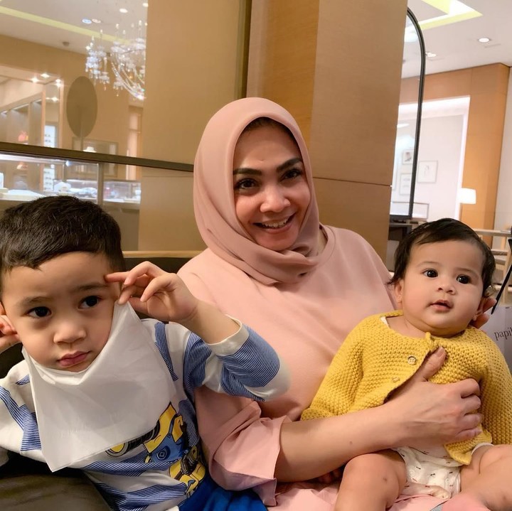 <p>Kendati sudah berusia 57 tahun, Rieta Amalia masih awet muda. Bahkan dia memiliki gaya berbeda saat momong kedua cucunya. (Foto: Instagram: @rieta_amilia)</p>