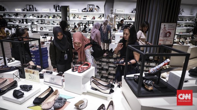 Pengunjung memilih sepatu di salah satu toko yang mengikuti midnight sale, di Grand Indonesia Mall, Jakarta, 31 Mei 2019.  Grand Indonesia Mall menggelar midnight sale pada tanggal 31 Mei  dan 1 Juni 2018. Midnight sale di Mal Grand Indonesia dimulai pukul 20.00 dan berakhir pukul 00.00 WIB. (CNNIndonesia/ Hesti Rika)