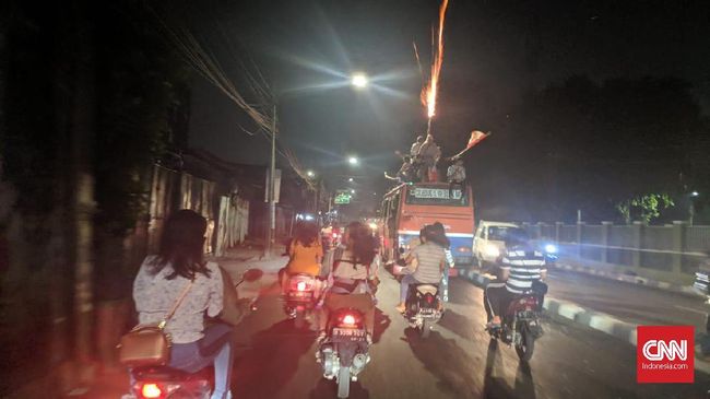 Aksi peserta takbir keliling dari Tanah Abang menyalakan flare atau lampu suar saat melintas di tengah jalan, Selasa (4/6).