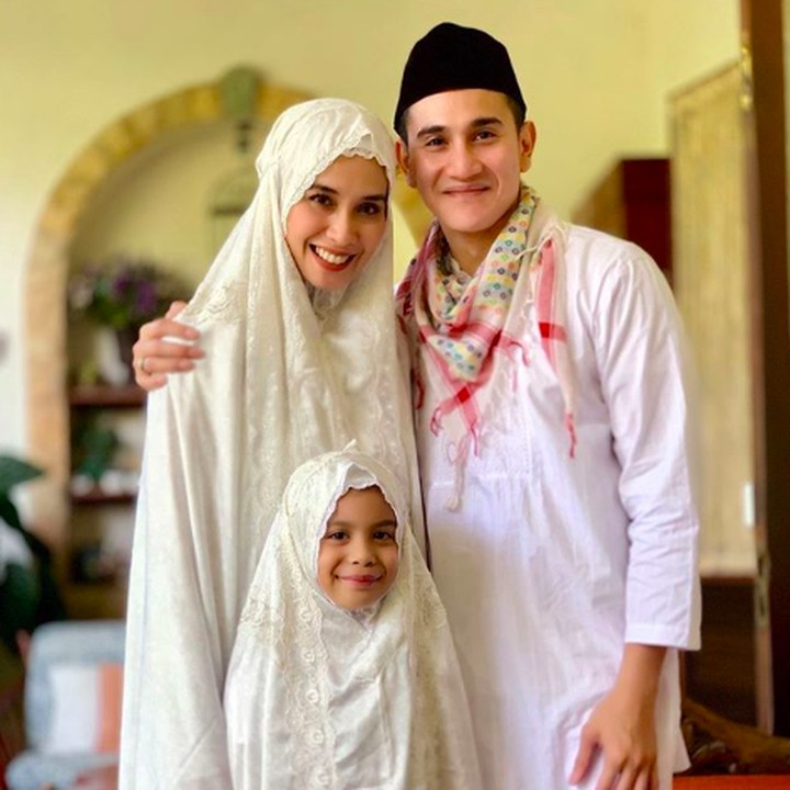 Vino G Bastian mengajak keluarga kecilnya untuk berfoto bersama setelah salat ied. Cantik banget ya Mama Marsha dan si kecil Jizzy mengenakan mukena. (Foto: Instagram @vinogbastian_)