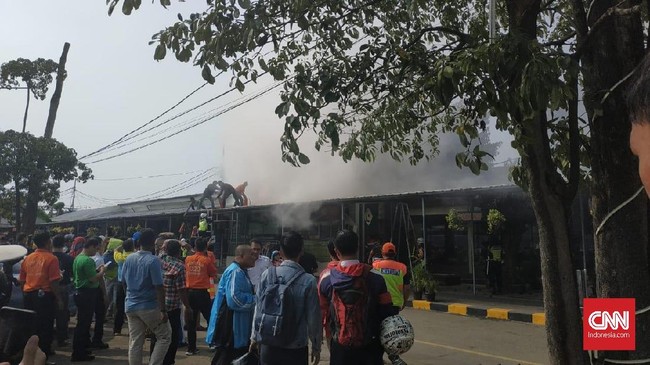 Asap tebal keluar dari salah satu minimarket Stasiun Pasar Senen, Jakarta, Sabtu (8/6). Asap akibat kebakaran itu diduga akibat korsleting listrik.