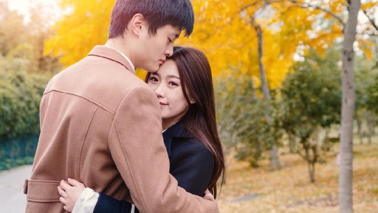 Chinese young man and woman hug and stand together with emotional expression, lover concept.