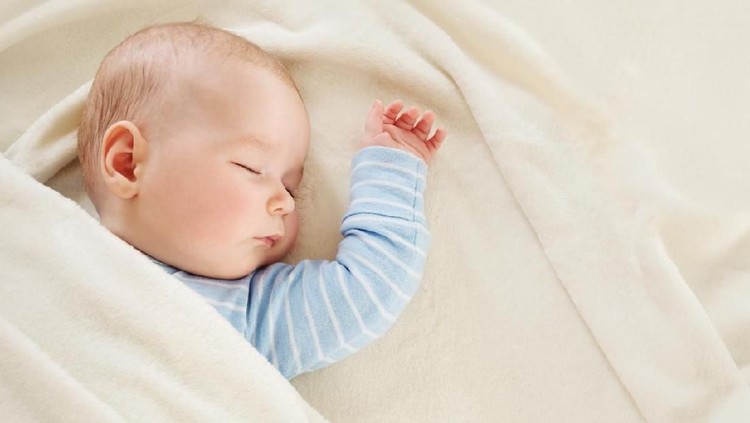 Close-up of sleeping baby hand in the mother's hand on the bed. New family and baby sleep concept