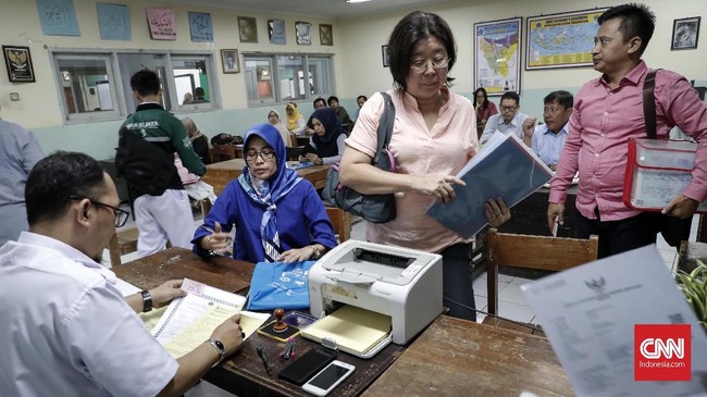 Orangtua siswa antre Pendaftaran Penerimaan Peserta Didik Baru (PPDB) di SMAN 8 Jakarta, Senin, 24 Juni 2019. Sesuai jadwal pendaftaran PPDB DKI Jakarta jalur zonasi SMP-SMA mulai dibuka 24 Juni hingga 26 Juni 2019. CNNIndonesia/Safir Makki