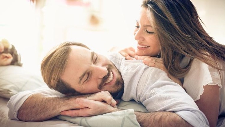 916000194 Happy young couple in bed. Space for copy.