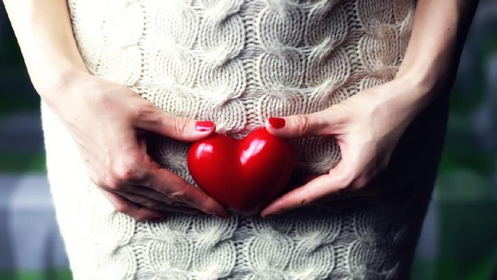 female hand holding a heart shape closeup
