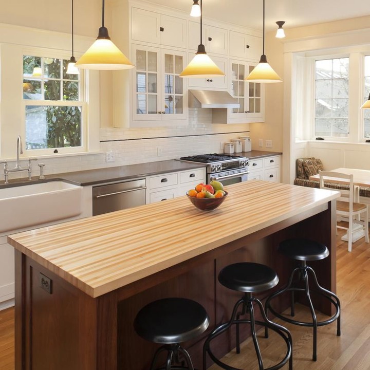 <p><em>Countertop</em> berbahan kayu pada <em>kitchen island</em> terlihat menonjol di antara dominasi warna abu-abu, metalik, dan putih. (Foto: iStock)</p>