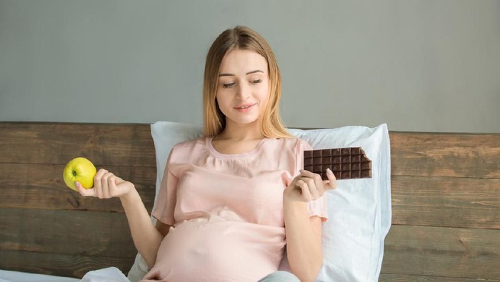 Pregnant woman at moments of rest in her kitchen