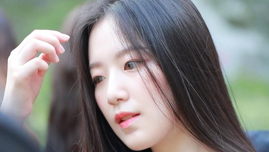 Shuhua tampil santai dengan kaos garis-garis dan tas selempang.