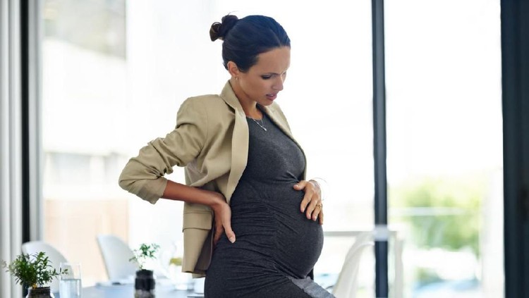Shot of a pregnant businesswoman in discomfort in her office