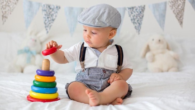 Ilustrasi bayi laki-laki Cute toddler child, baby boy, playing with colorful toy in sunny bedroom, flag banner decoration behind him