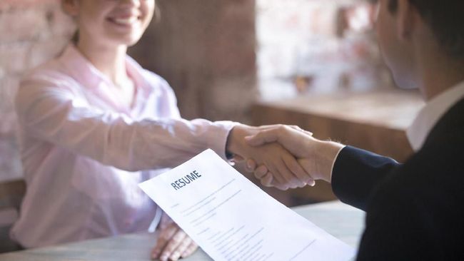 Smiling young woman and man handshake. Businesspeople shaking hands. Human resources, successfully passing the interview, hr concept. Close up resume paper