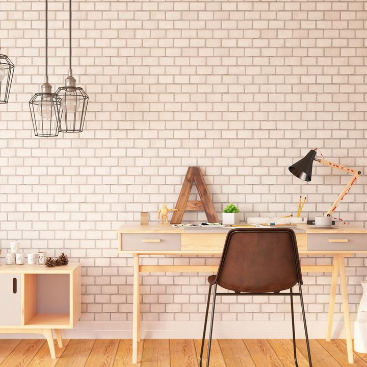 Penggunaan warna yang monokrom dan senada baik tembok maupun perabot, bikin enggak terlihat berantakan walau banyak barang yang Bunda letakkan di meja kerja. (Foto: iStock)